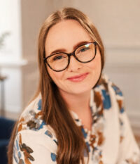 Portrait of Autumn Bailey, Registered Psychotherapist (Qualifying), smiling in a warm, professional setting.